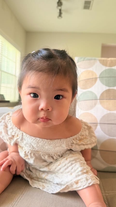 Laila in a cream dress with curious eyes