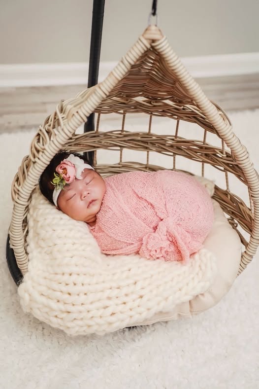 Laila sleeping in a hanging wicker basket