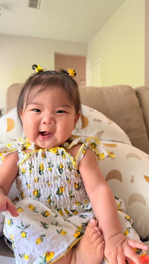 Laila laughing in a lemon-print dress